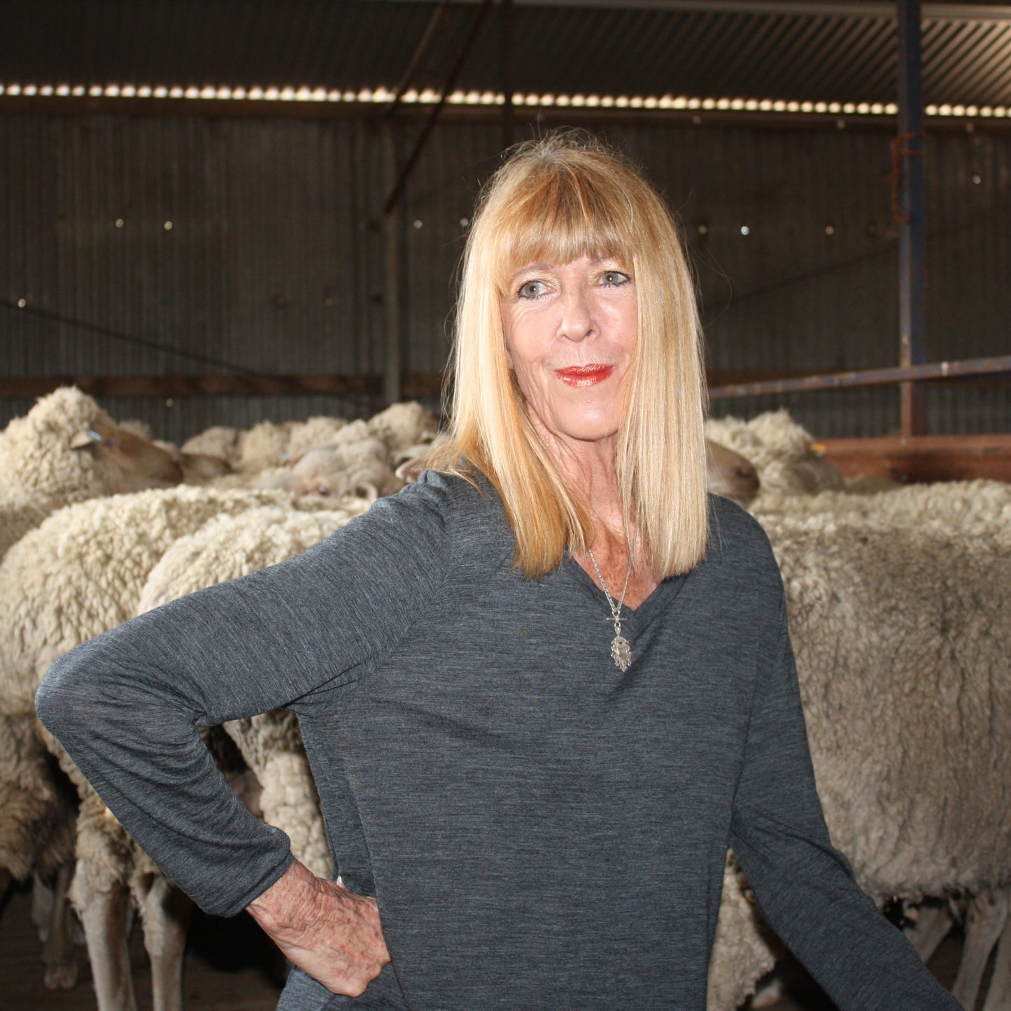 woman with sheep wearing charcoal Merino long sleeve tee
