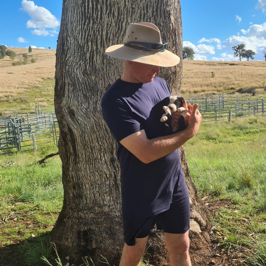 Murray holding puppy wearing Merino tee