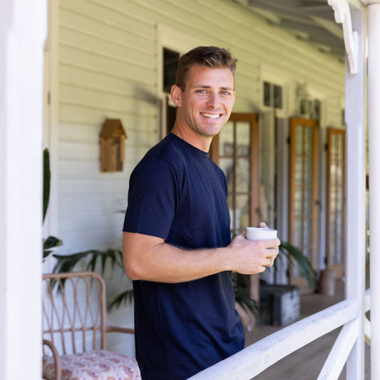 Smiling model on verandah wearing a Sleepy Merino tee