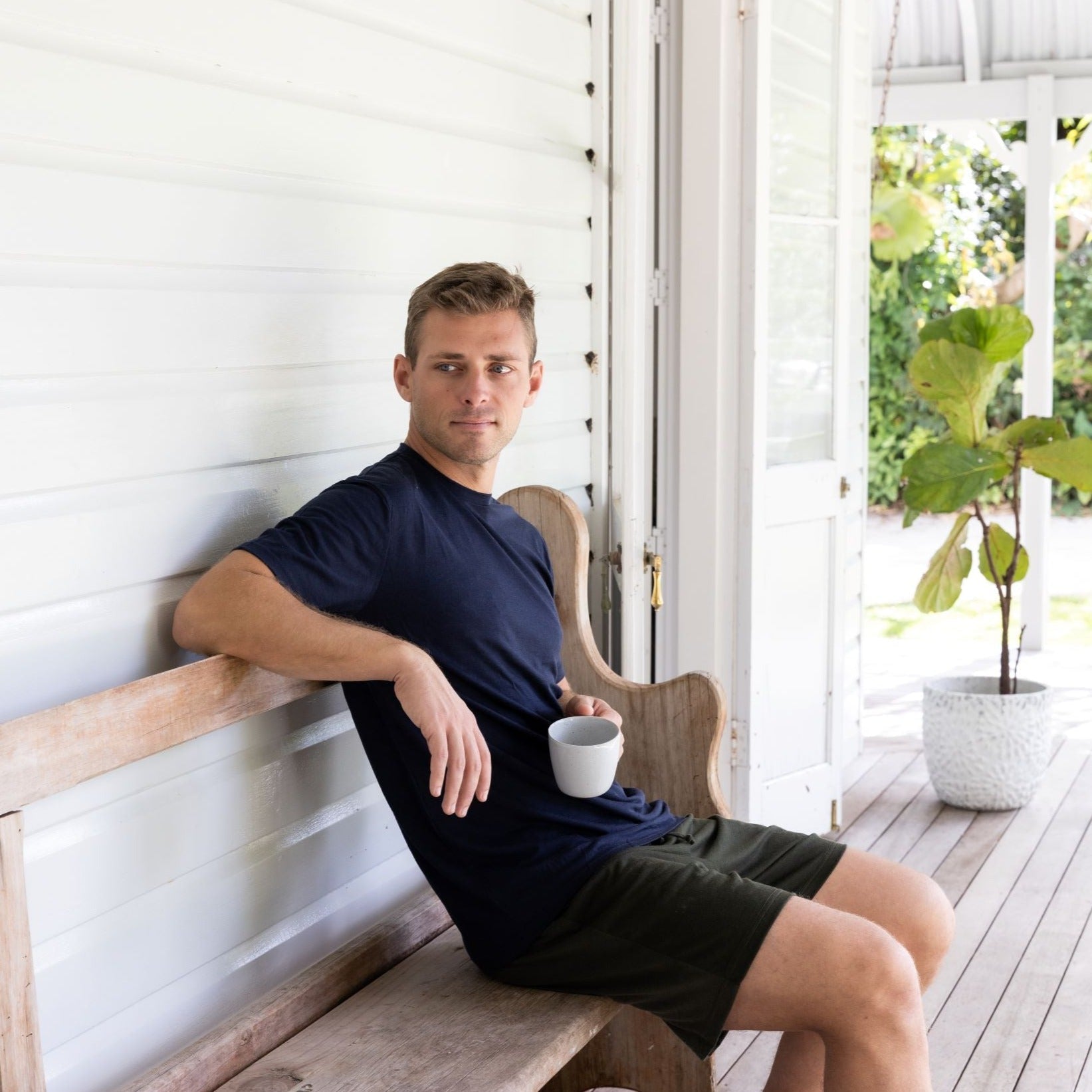Sitting on a bench in a navy Merino tee
